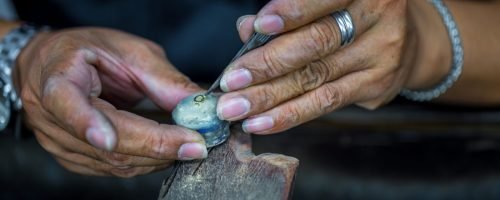 Thai jeweler, handles the jewelry and precious stones in the workshop, the process of jewelry making ,close-up